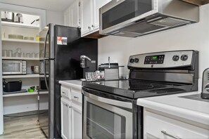 The beautiful kitchen includes a wide range of cookware including, an air fryer, blender, and a crockpot.