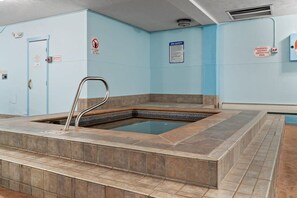 A spa area with a hot tub, a safety sign, and an emergency shutoff switch. - Chic 2BDR Downtown Condo; Walk Everywhere! (Breckenridge)