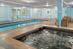 An indoor swimming pool with a diving board, a changing room, and a seating area with tables and chairs. - Chic 2BDR Downtown Condo; Walk Everywhere! (Breckenridge)