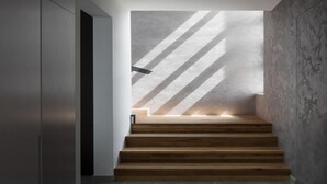 A modern staircase with wooden steps and a concrete wall with diagonal shadows. - Villa Noble 1 with Spa (Bale)