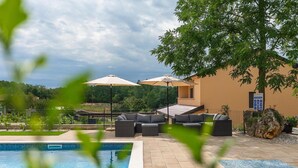 A poolside area with lounge chairs, umbrellas, and a sign indicating a shopping pool. - Lovely home in Motovun (Motovun)