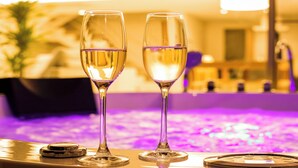 Twee champagneglazen op een tafel, met een zwembad op de achtergrond.