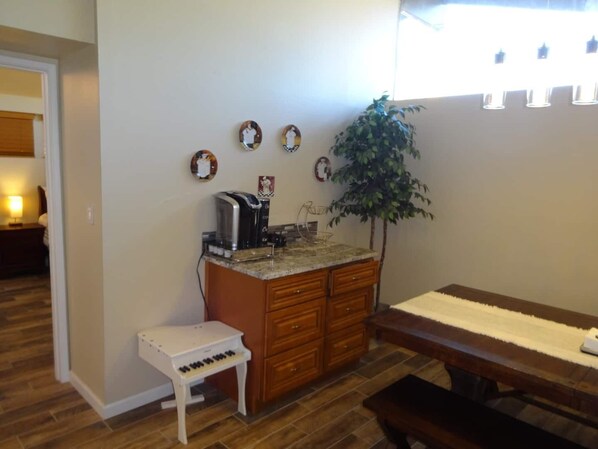A compact kitchen with a coffee maker, a small piano, and a dining table. - Great conveniently located home. Near mall and many restaurants. (Tucson)