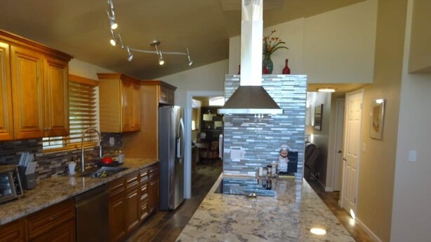 A modern kitchen with wooden cabinets, a granite countertop, and a central island. - Great conveniently located home. Near mall and many restaurants.  (Tucson)
