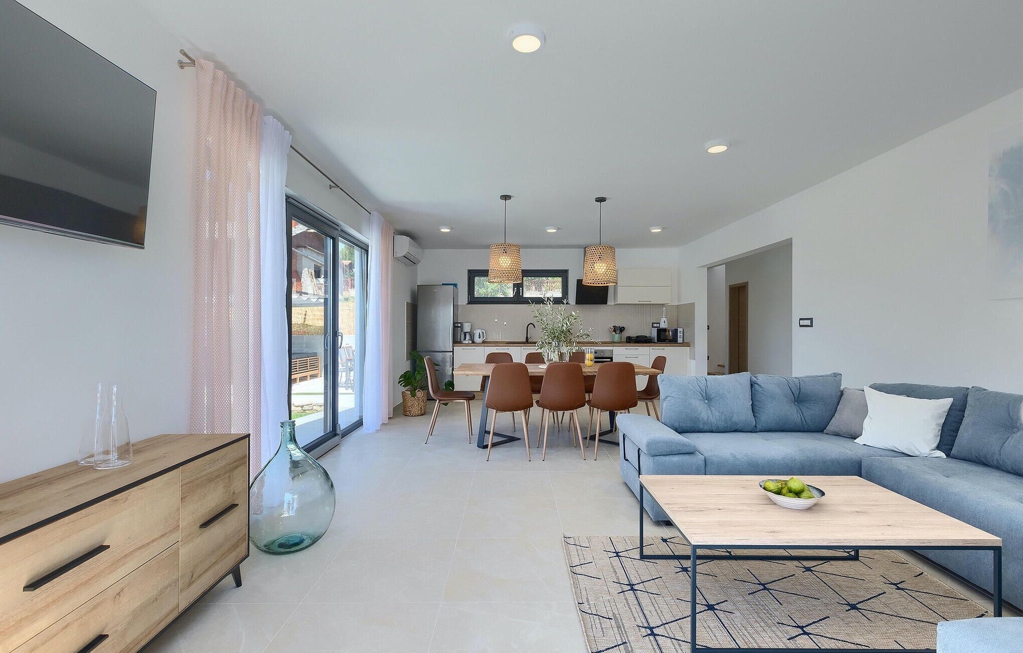A modern living room with a sofa, coffee table, and dining area.