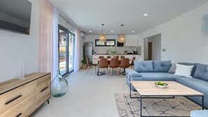 Un salon moderne avec un canapé, une table basse et un coin repas.