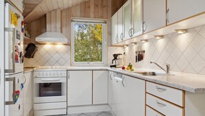 Una cocina moderna con armarios blancos, estufa y lavamanos.