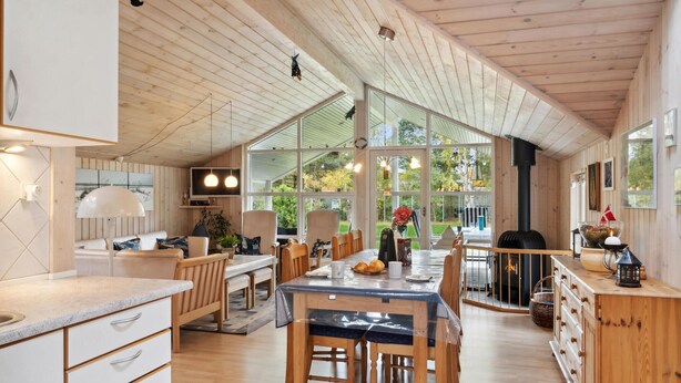 Una cocina amplia con armarios de madera, un comedor con una mesa grande y una chimenea acogedora.