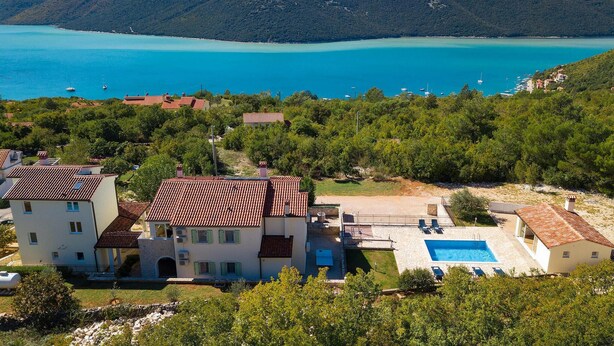 A coastal property with a swimming pool, multiple buildings, and a view of the sea. - Lovely home in Labin - Rabac (Labin - Rabac)