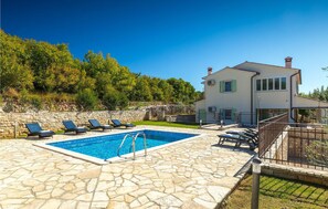 A pool area with stone flooring, a pool, and lounge chairs. - APARTMENT OLIVA VERDE (Labin - Rabac)
