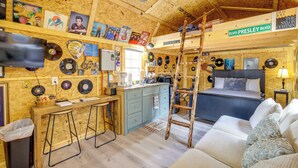 A cozy cabin with a kitchen, bar area, and a bed.