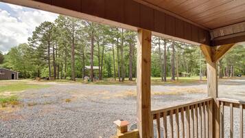 Guests can enjoy a peaceful porch with a bench and a gravel driveway leading to a parking area.