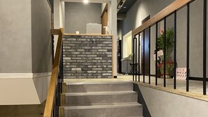 A staircase with a wooden handrail and a stone wall at the top. - Mange Tak Resort Onomichi (Onomichi)