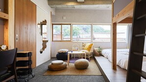 A compact, well-lit room with a bunk bed, a small table, and a chair. - Mange Tak Resort Onomichi (Onomichi)