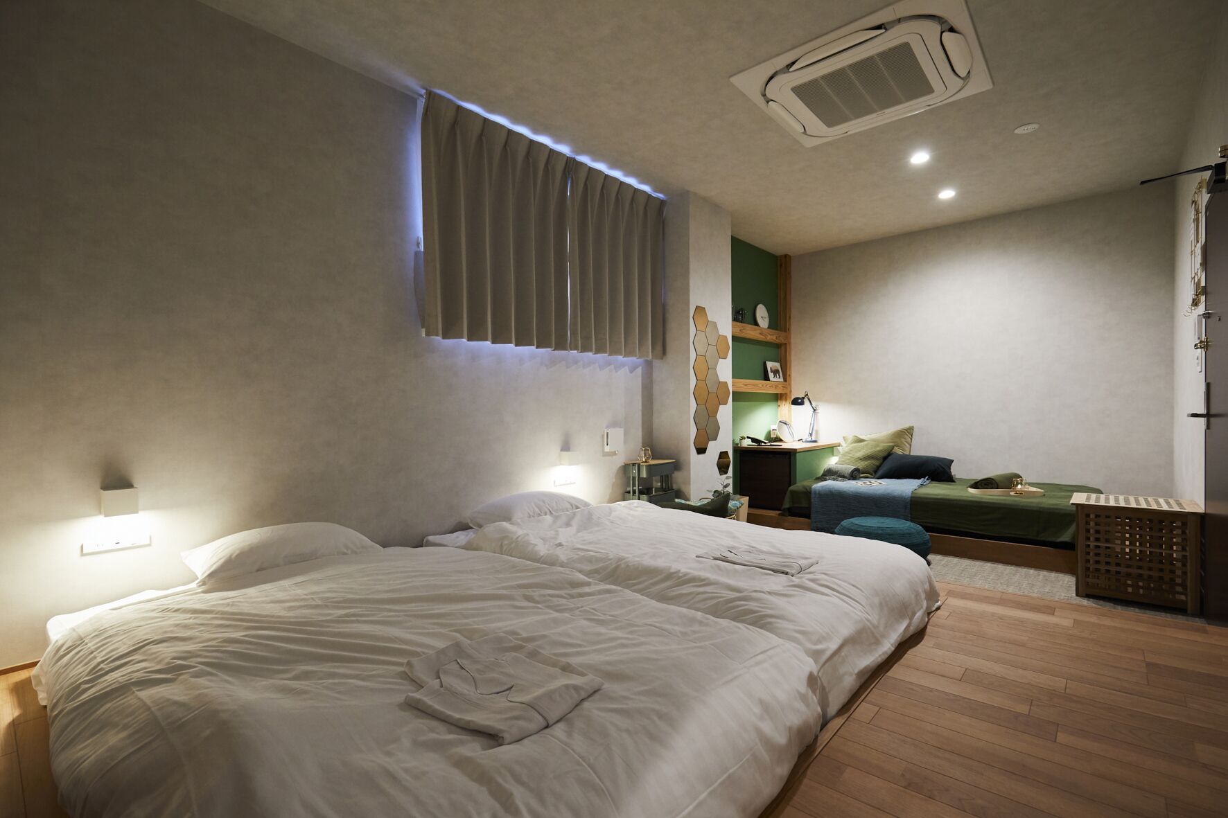 Un dormitorio con dos camas, un escritorio, una silla y un armario.