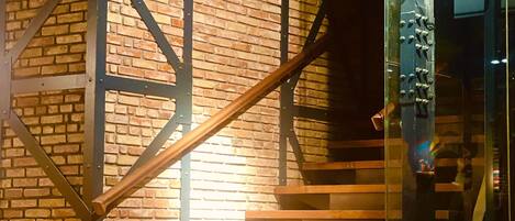 Eine Treppe mit Metallgestell und Holzstufen, die zu einer Glastür führt.