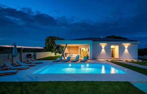 A modern house with a swimming pool, outdoor seating, and a well-lit entrance. - Amazing home in Krnica (Krnica)