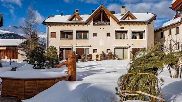 Un immeuble à étages doté d’une façade symétrique, de grandes fenêtres et d’un toit recouvert de neige.