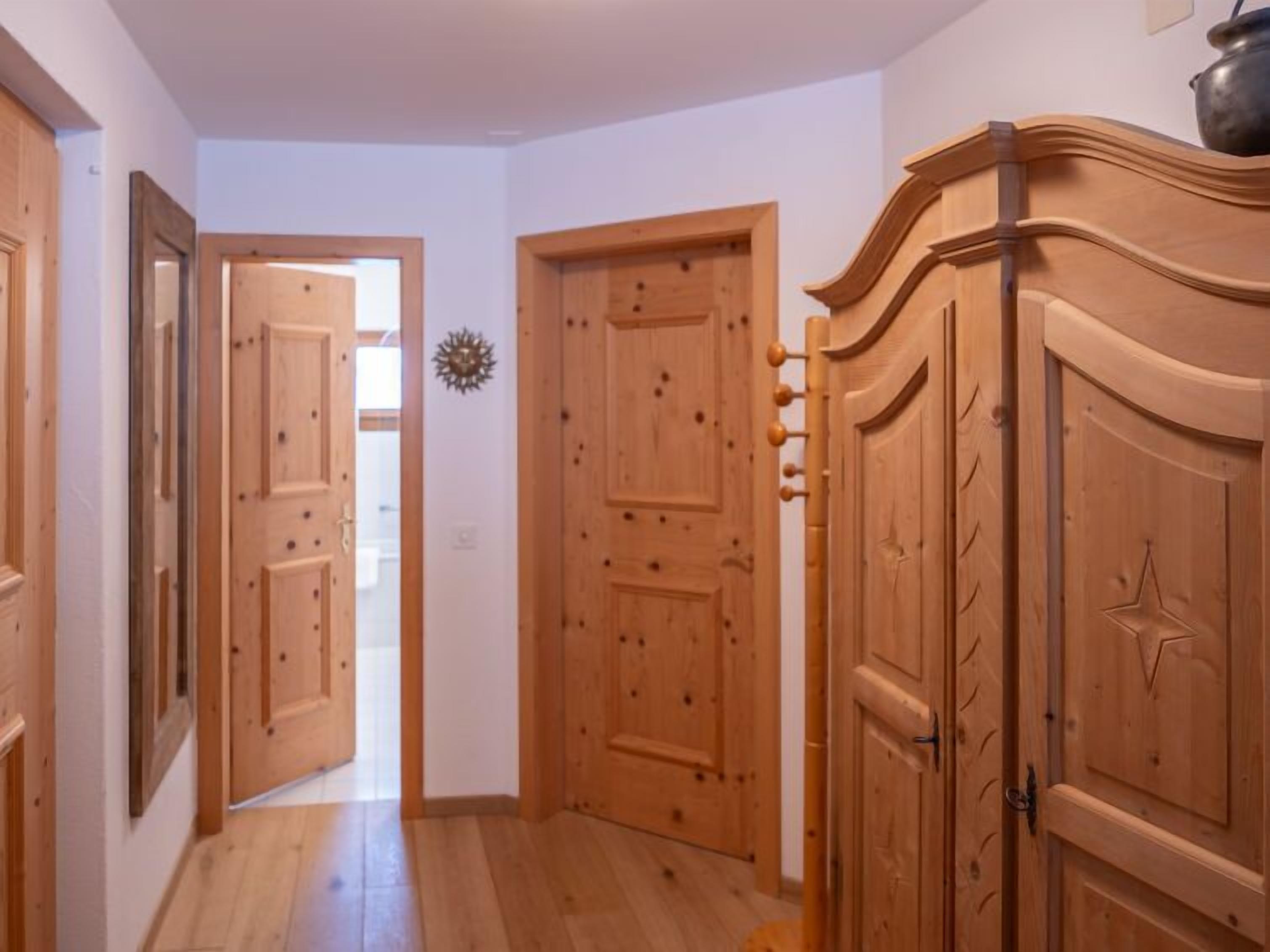 Ein Korridor mit Holztüren und einem Holzkabinett.