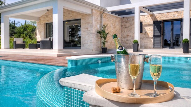 A poolside area with a champagne bottle, glasses, and a tray. - Beautiful home in Porec (Porec)
