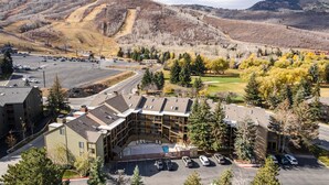 Un hôtel à plusieurs étages doté d’une piscine, d’un parking et offrant une vue sur les collines environnantes.