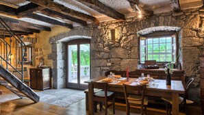A rustic dining area with stone walls, wooden beams, and a stone fireplace. - Beautiful home in Buzet (Buzet)