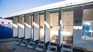 Portable portable toilets with metal steps and a sign instructing to keep clean and tidy.