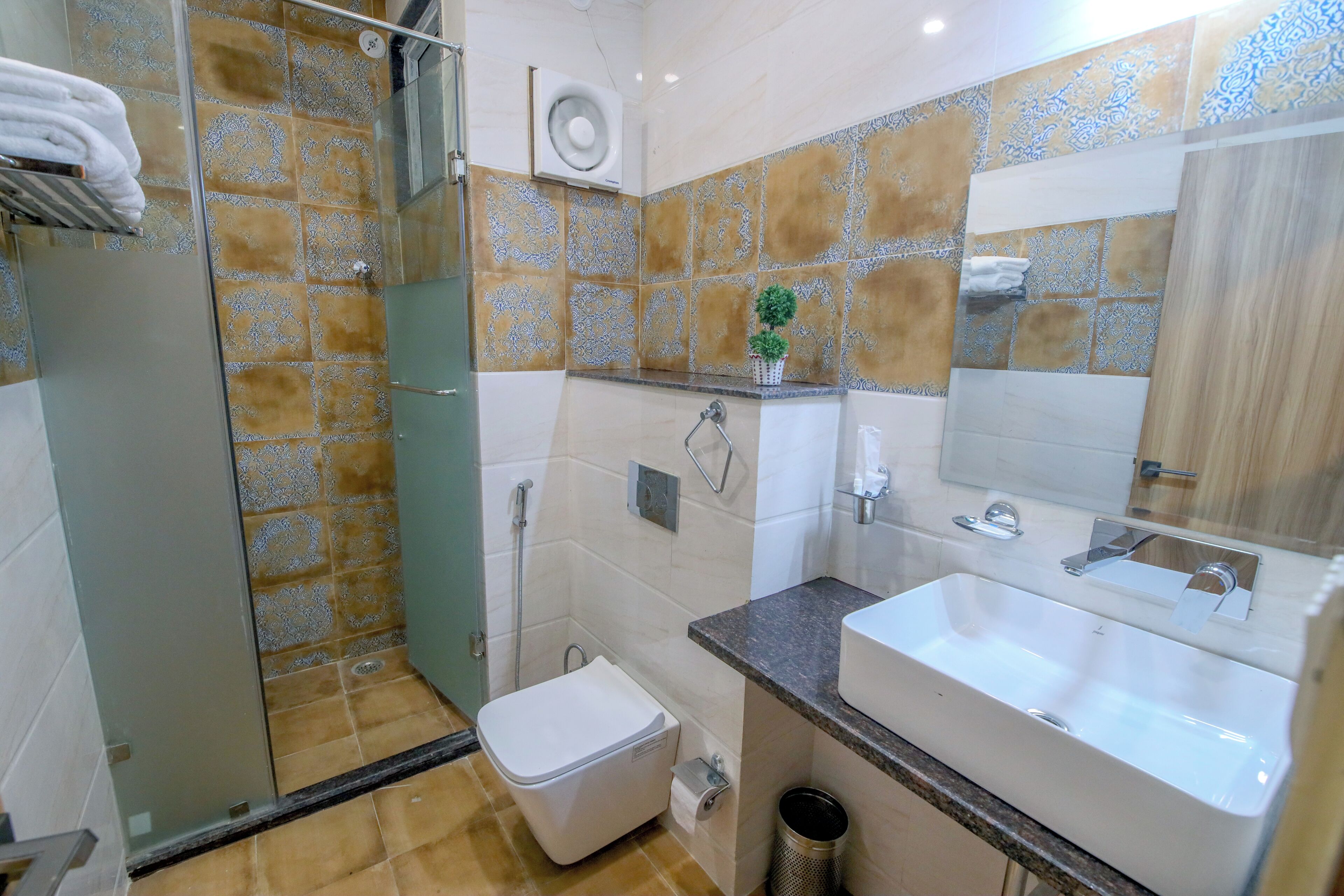 Une salle de bain équipée d’une douche, de toilettes, d’un lavabo et d’un miroir.
