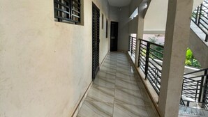 A corridor with tiled flooring, a ceiling light, and a railing on the right side. - Residence in Tounkaranké (Bamako)