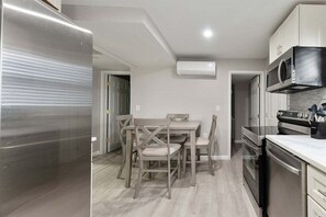 Una cocina moderna con un refrigerador de acero inoxidable, un microondas integrado y una estufa a gas.