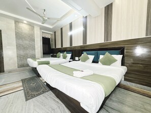 A hotel room with two beds, a ceiling fan, and a view of the hallway. - Hotel Alpine By The Golden Taj Group (Agra)
