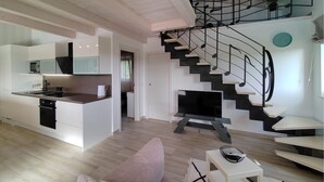 Un appartement moderne comprenant une cuisine, un espace de vie et un escalier en colimaçon.