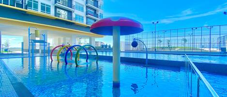 Ein Swimmingpool mit Wasserrutsche und bunten Ringen.