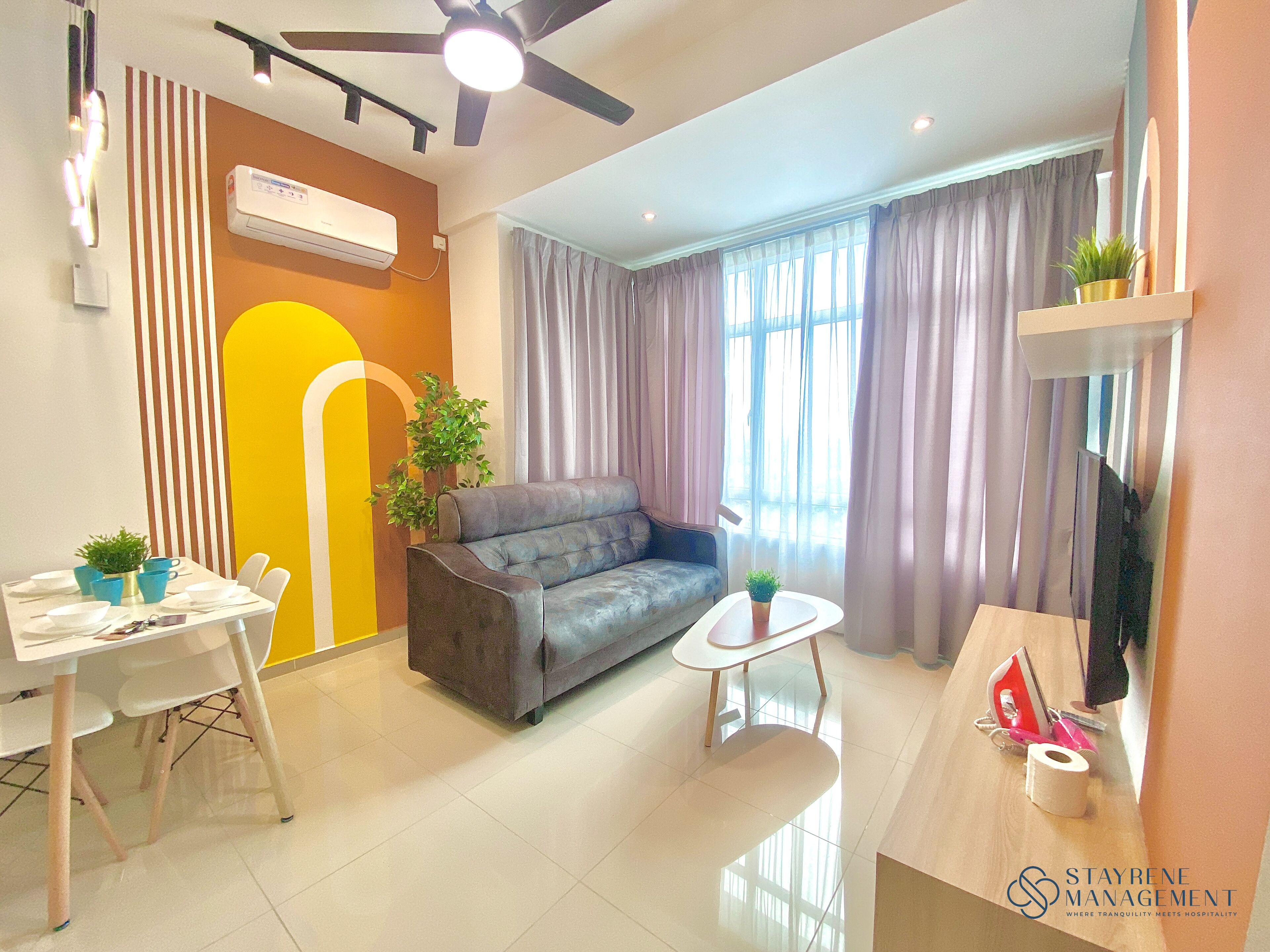 A modern living room with a sofa, a dining table, and a ceiling fan.