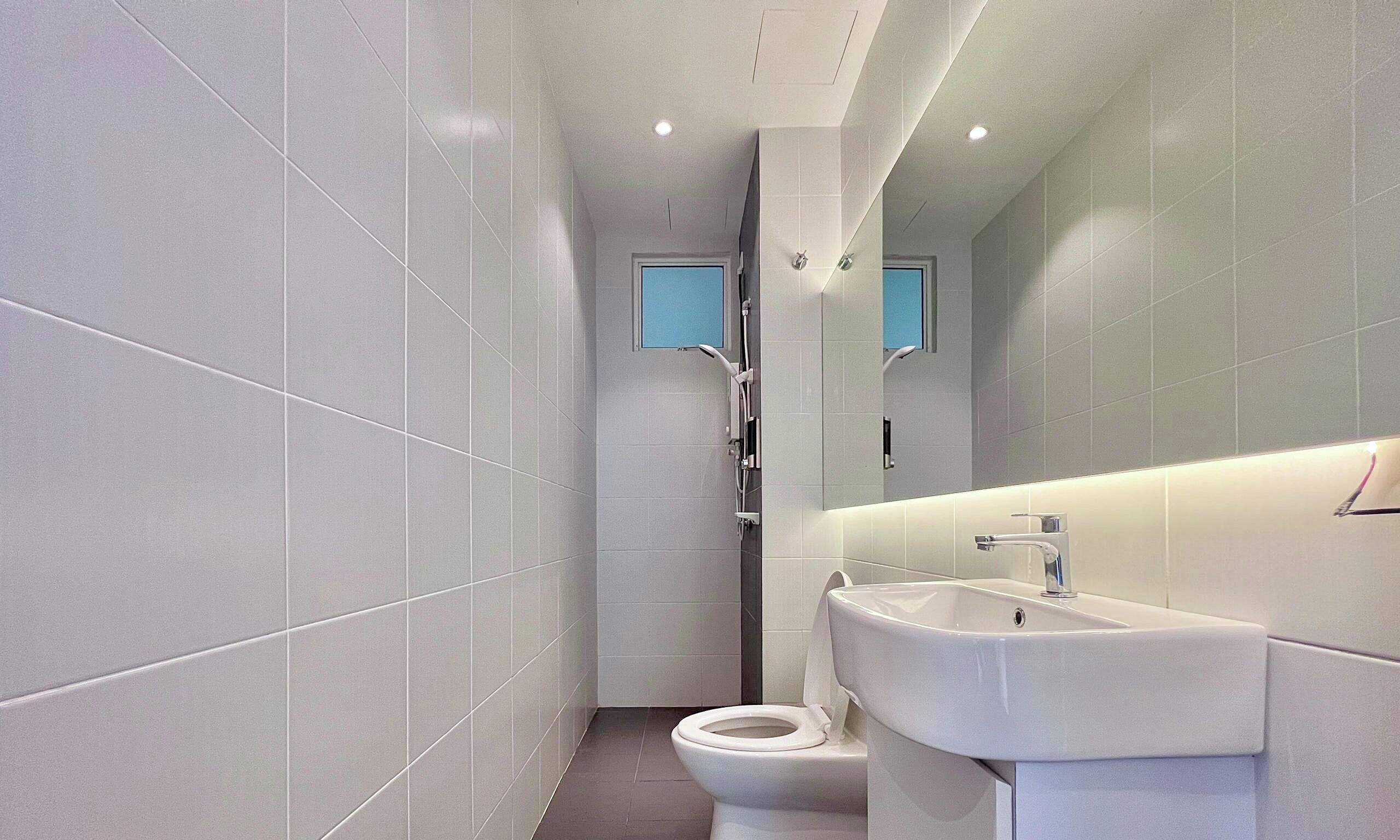 A modern bathroom with a toilet, sink, and shower.