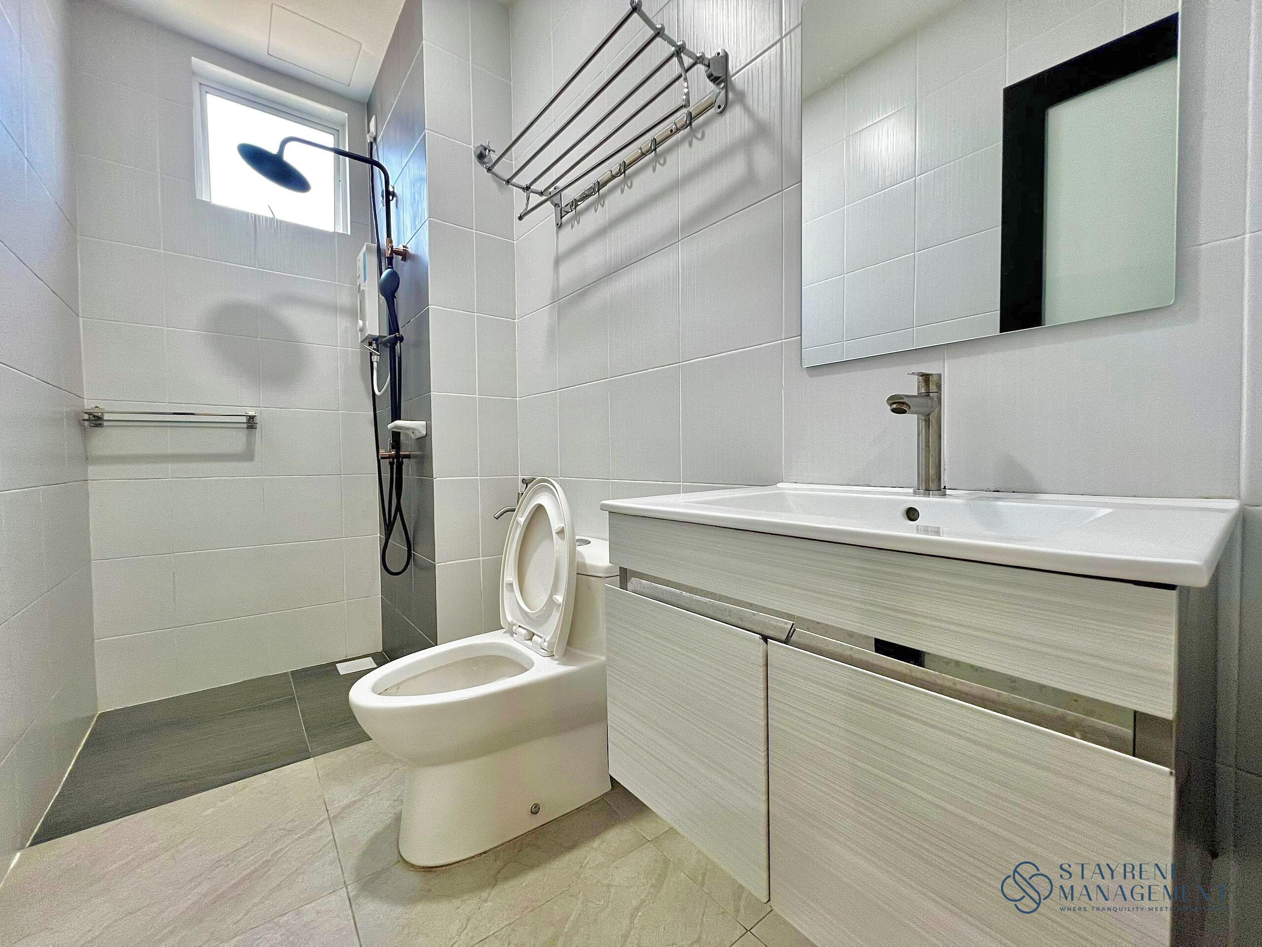 A modern bathroom with a toilet, sink, and shower.