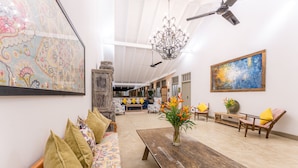 A spacious living room with a wooden coffee table, a sofa with patterned cushions, and a large abstract painting on the wall. - The Fort House (Galle)