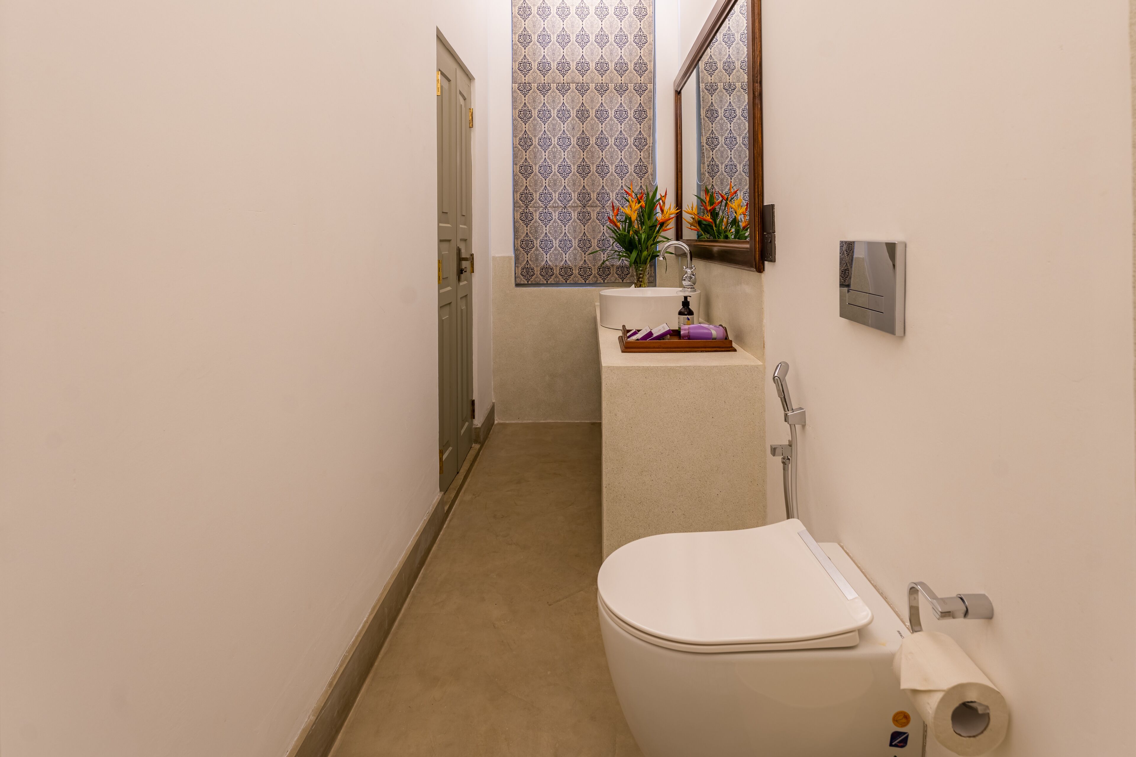 Un baño pequeño con inodoro, lavamanos y espejo.