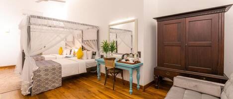 A bedroom with a bed, bedside table, chair, desk, wardrobe, and ceiling fan.