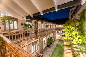 A courtyard with a covered walkway, potted plants, and outdoor seating. - The Fort House (Galle)