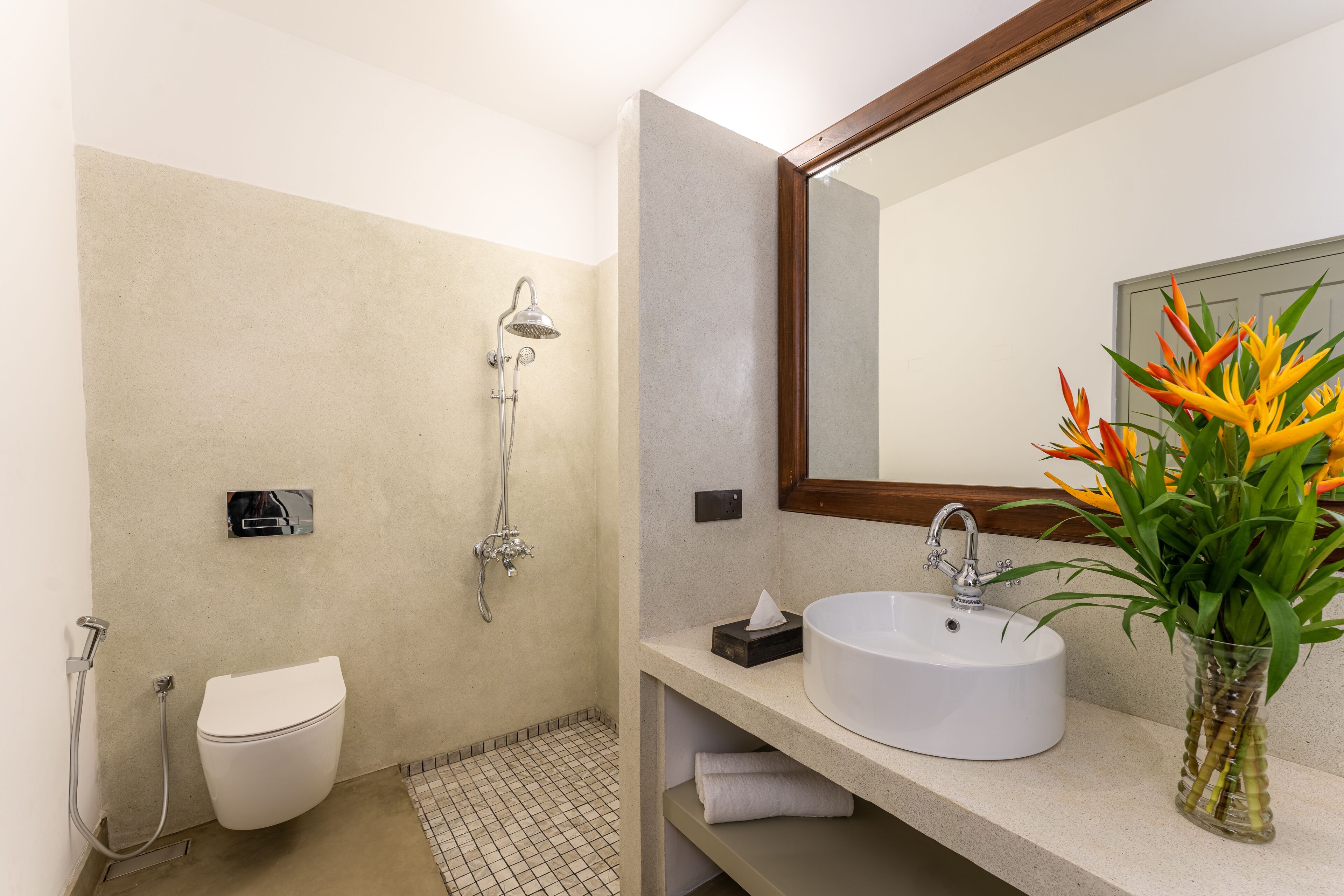 Une salle de bain moderne équipée de toilettes, d’une douche, d’un lavabo et d’un miroir.