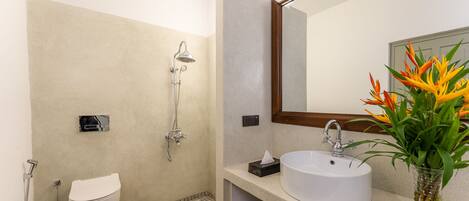 Une salle de bain moderne équipée de toilettes, d’une douche, d’un lavabo et d’un miroir.