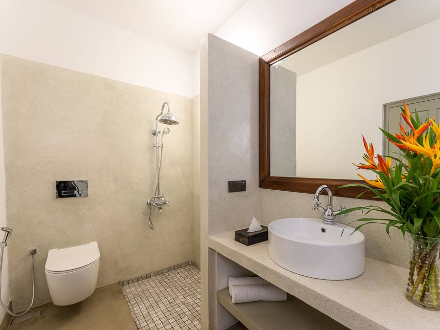 Une salle de bain moderne équipée de toilettes, d’une douche, d’un lavabo et d’un miroir.