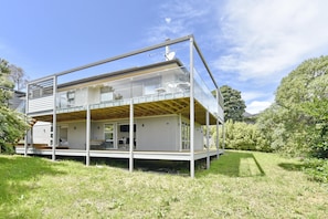 Uma casa moderna de dois andares com varanda, antena parabólica e deck de madeira.