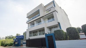 A modern building with a sign for 'treebo' and 'FlxHo' on the ground floor. - Treebo FlxHo Trio, Medanta Medicity Gurgaon (Gurugram)