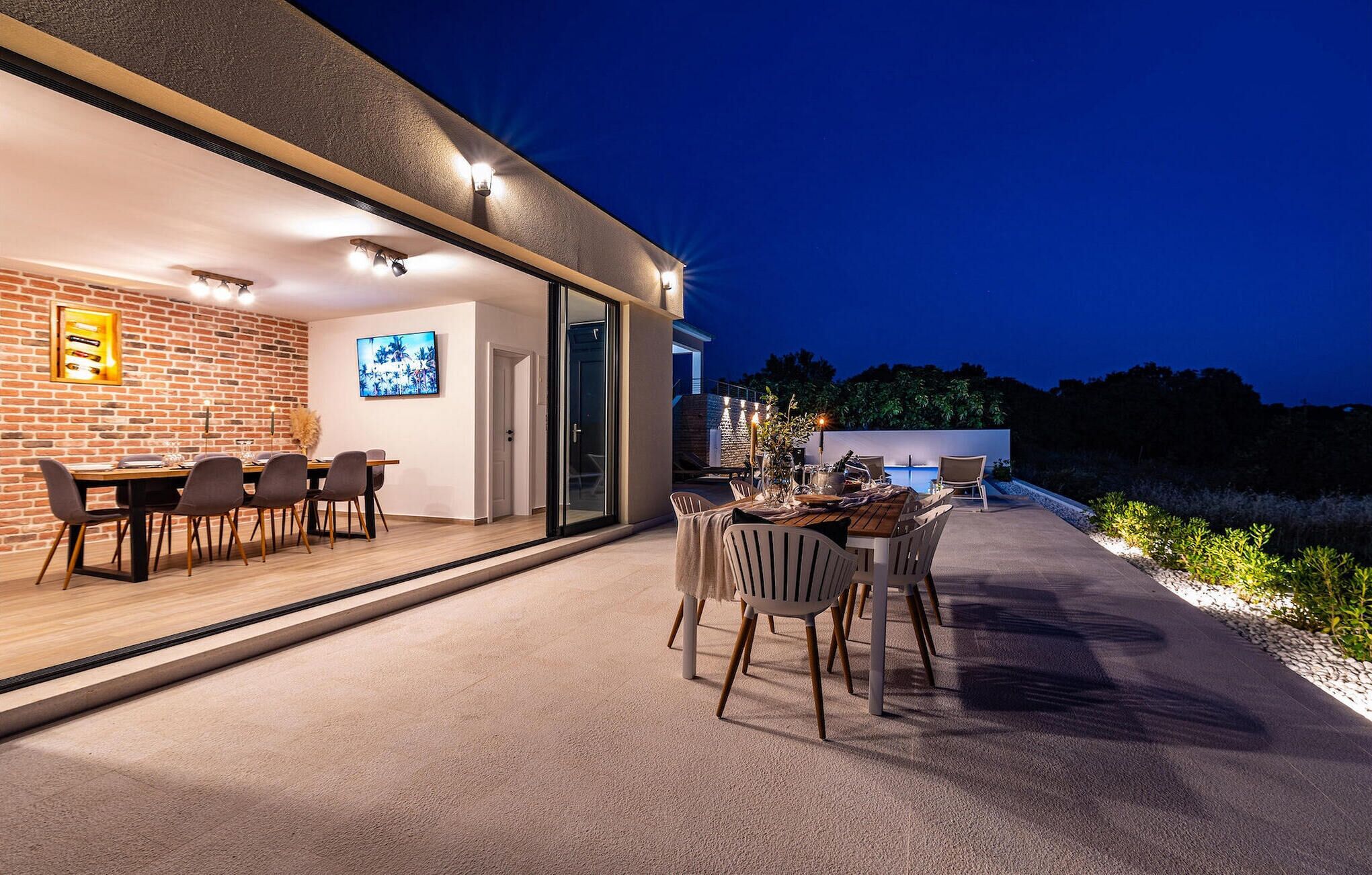 An outdoor dining area with a brick wall and a view of the sky.