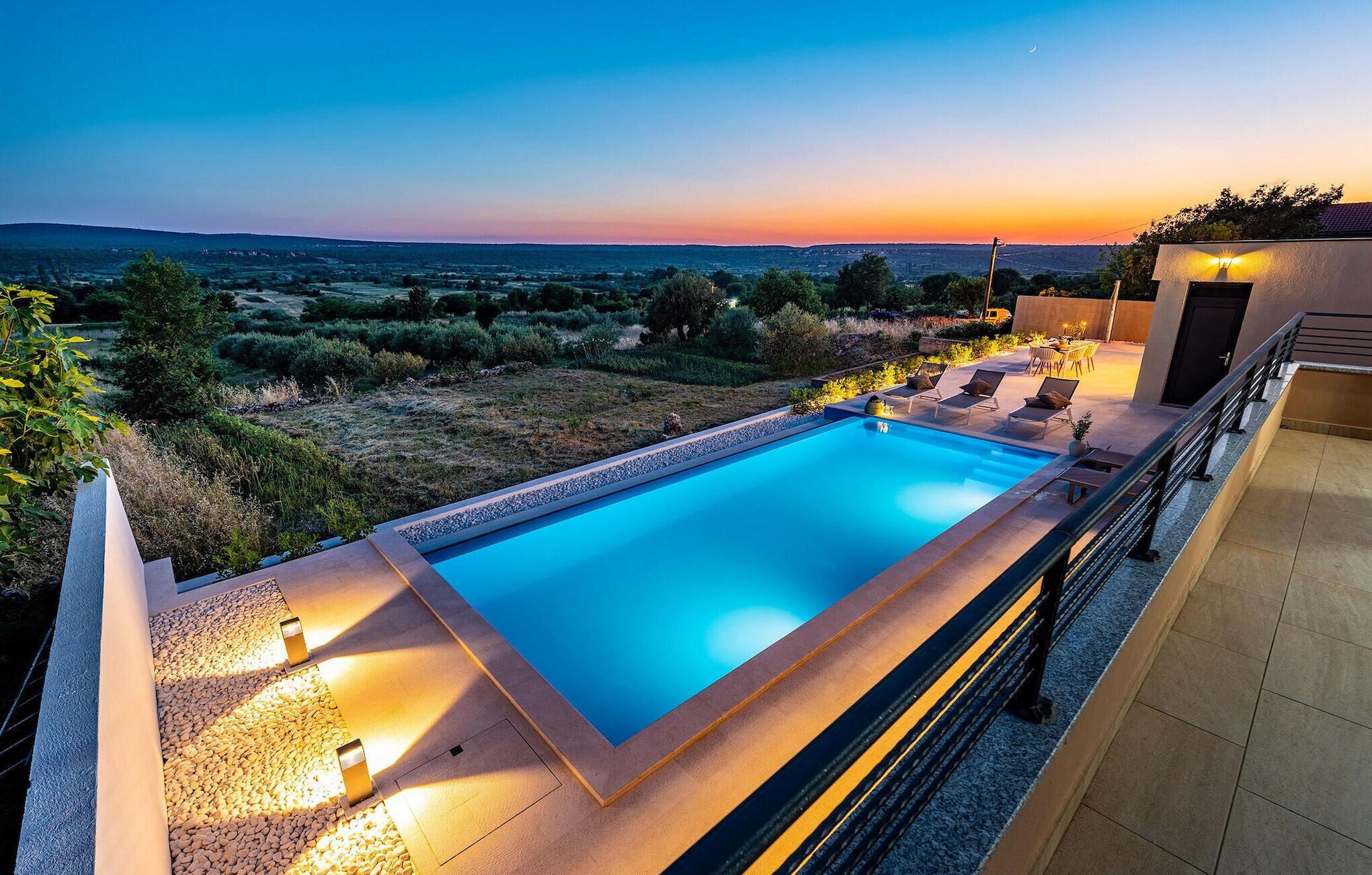 Ein rechteckiger Pool mit freiem Blick auf die Landschaft im Hintergrund.
