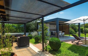 A modern outdoor patio with a covered seating area, a dining table, and a lounge chair. - Amazing home in Rovinj (Rovinj)
