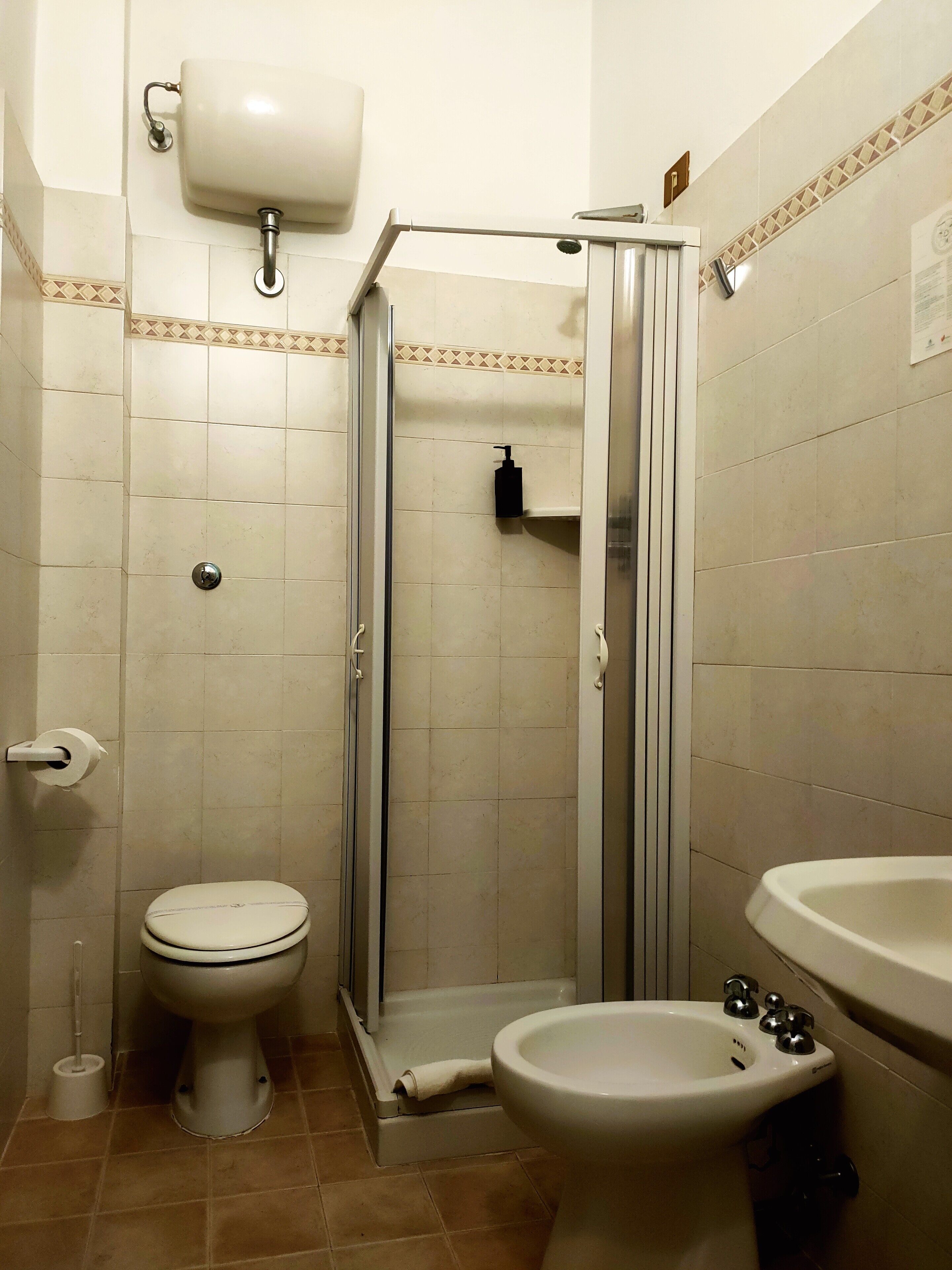 Une salle de bain équipée de toilettes, d’un bidet et d’un lavabo.