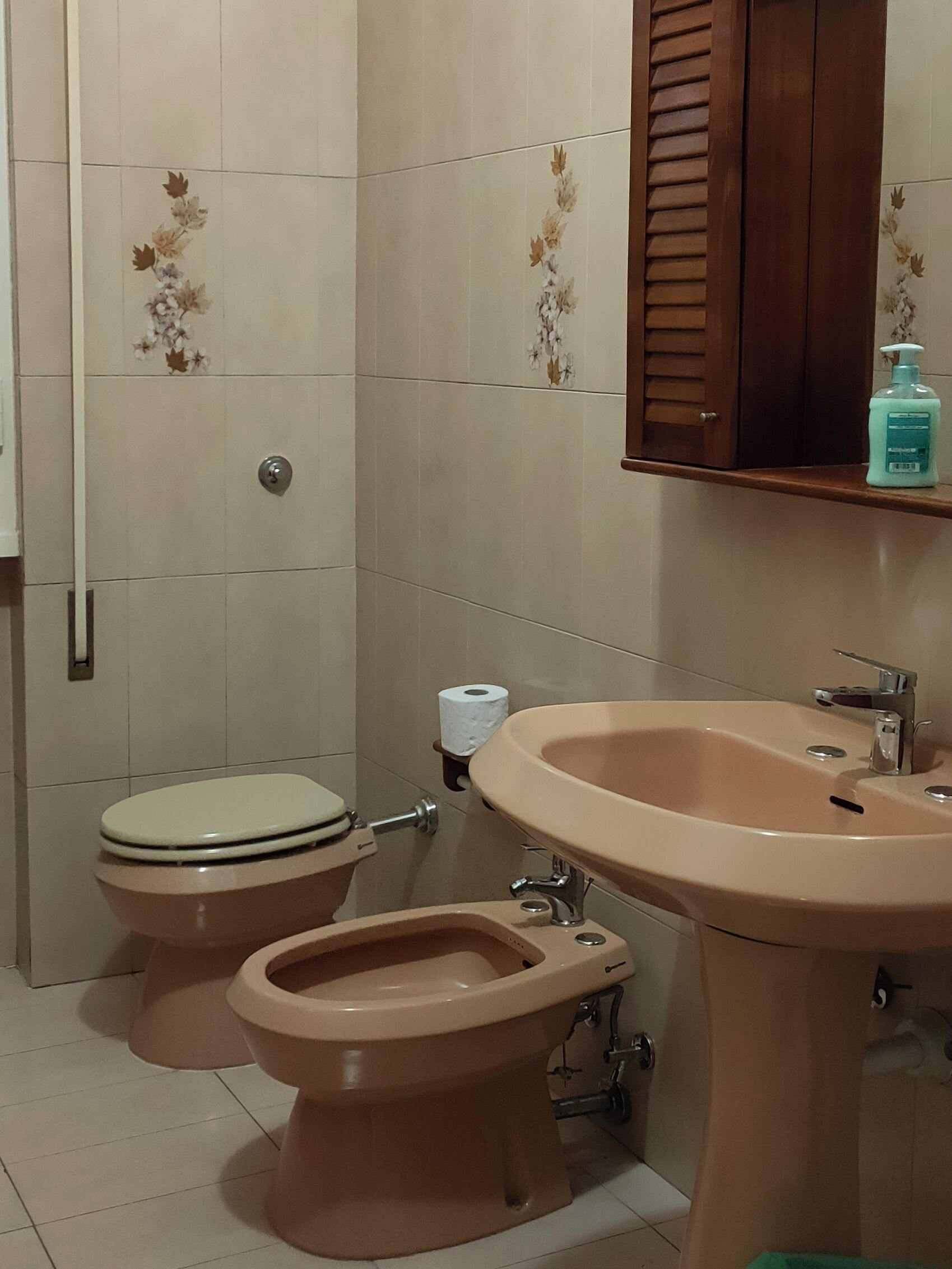 A bathroom with a toilet, bidet, and sink.